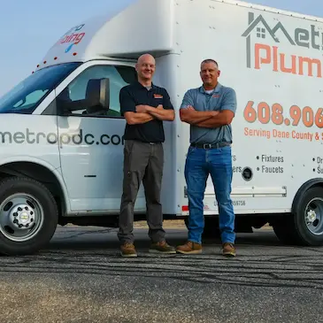 Co-owners and founders, Luke Bauer and Derek Schmidt, standing in front of metro plumbing truck