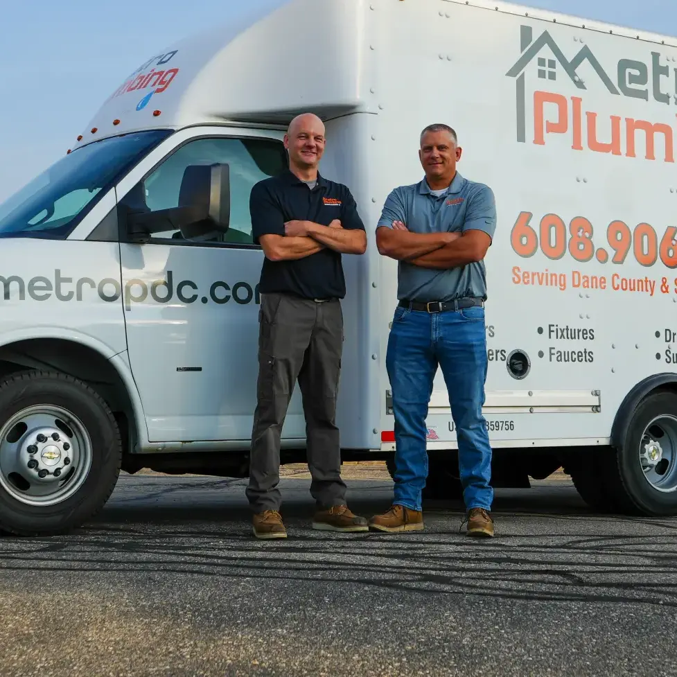 Co-owners and founders, Luke Bauer and Derek Schmidt, standing in front of metro plumbing truck