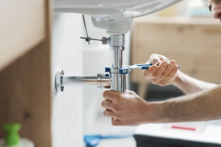 Worker working on the plumbing underneath a sink
